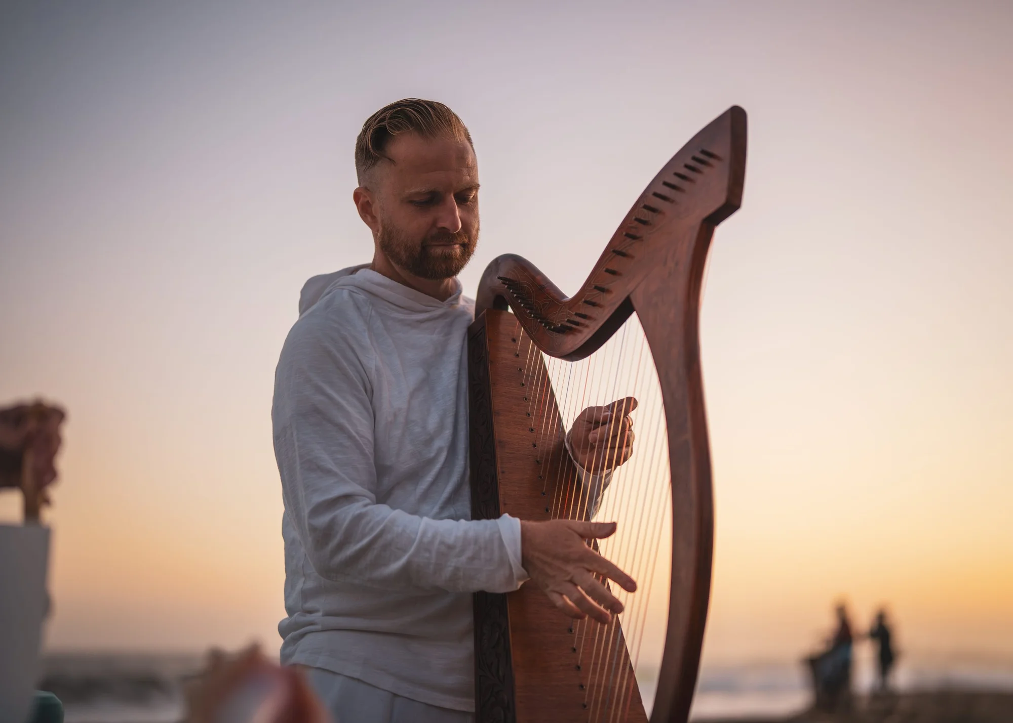 Justin Mosley playing harp at dusk