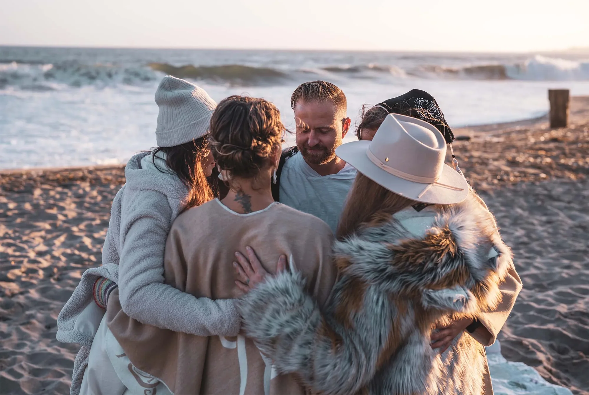 A Lovebyrds gathering embracing on the beach