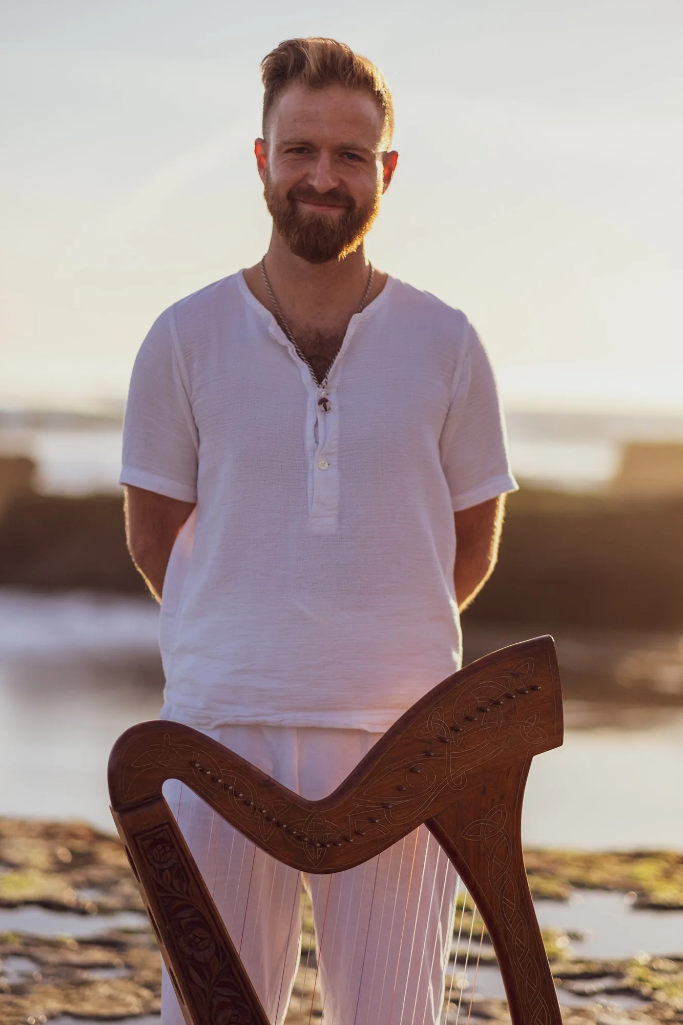 Justin Mosley at dusk with his Celtic harp